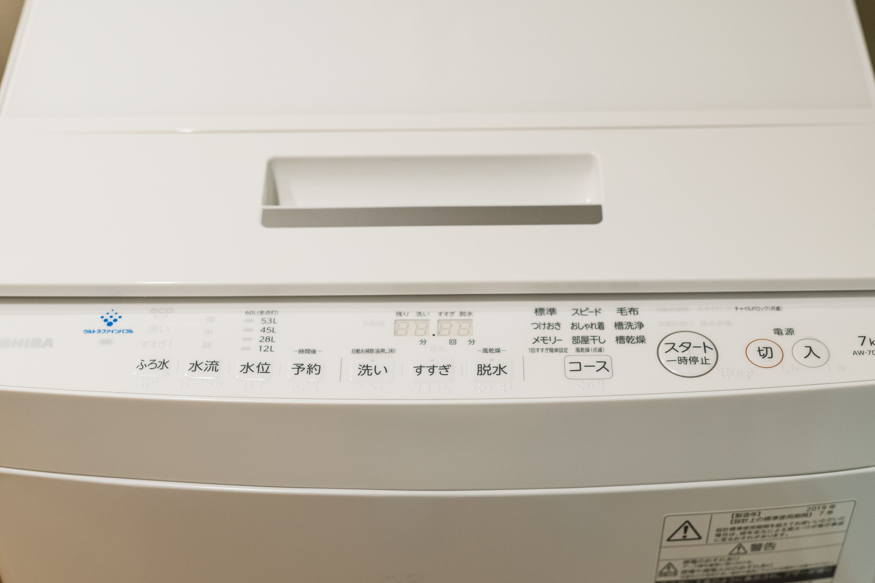 A white electronic device with Japanese text and symbols, including a power button and a reset button.