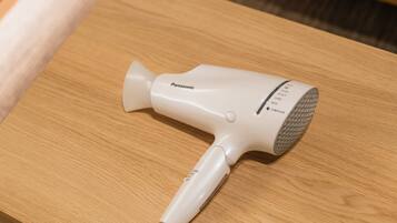 A Panasonic hair dryer on a wooden table.