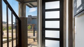 En modern entré med en glasdörr och ett metallstaket.