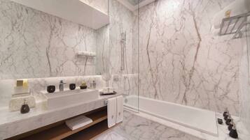 A modern bathroom with a marble vanity, a large mirror, a bathtub, and a shower area.