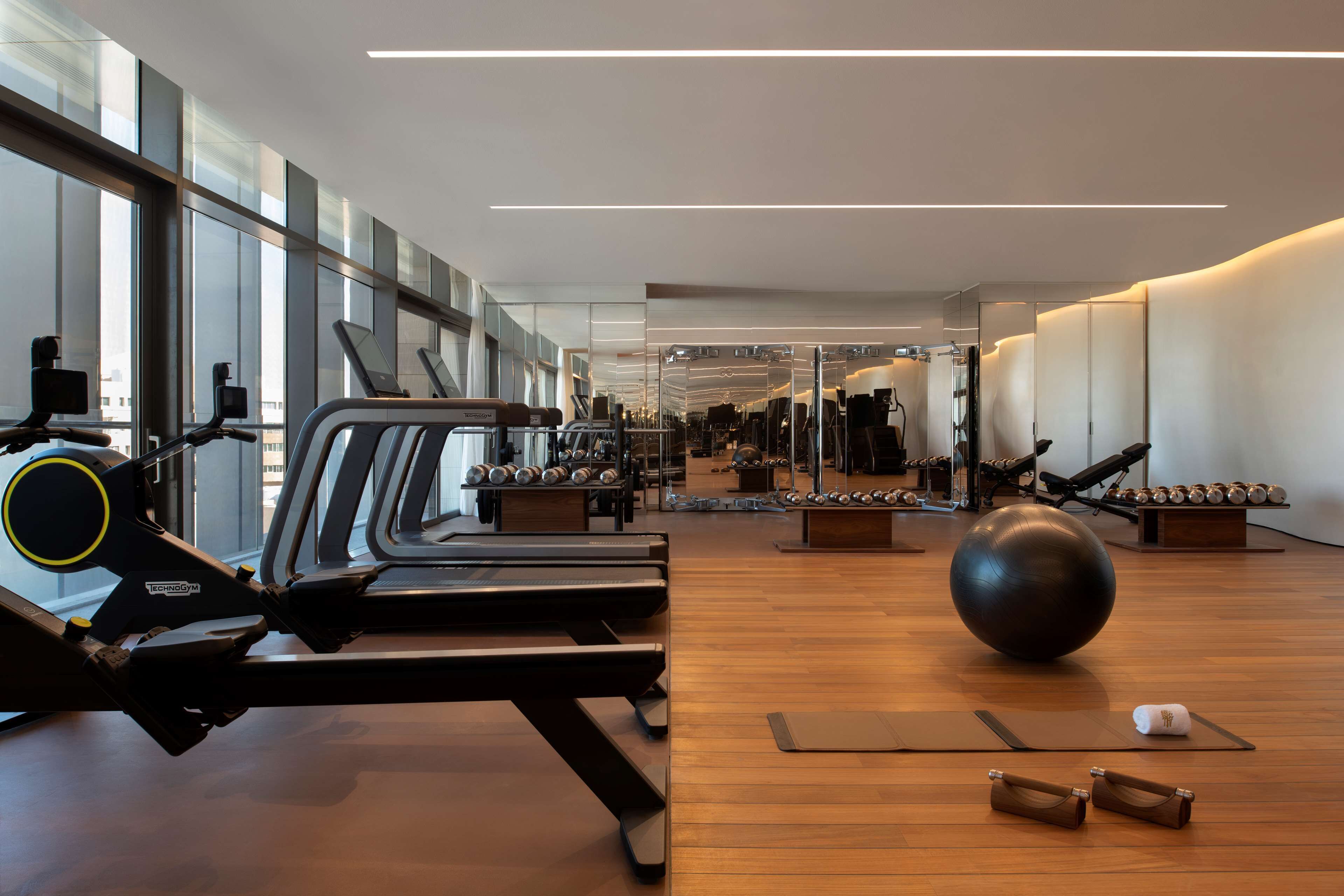 Ett modernt gym med löpband, träningsbollar och vikter.