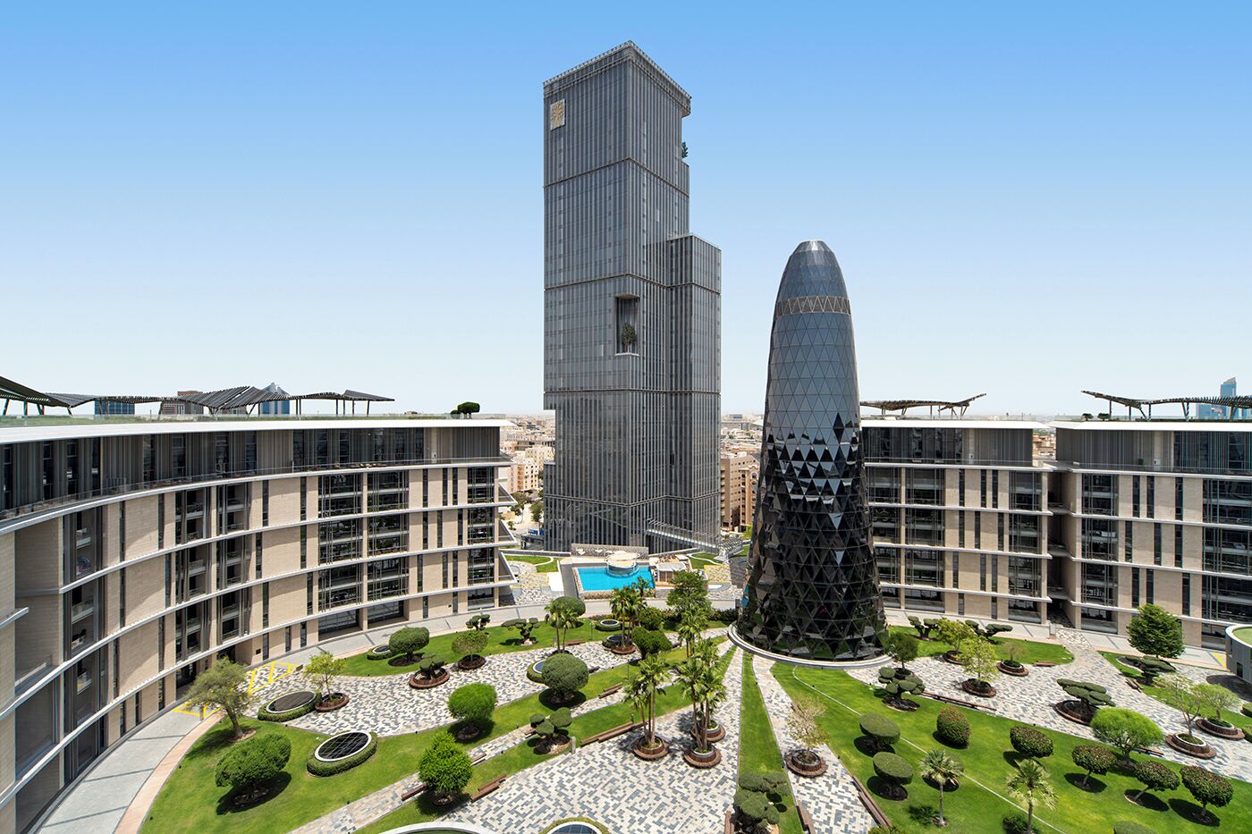 A modern building complex with a central tower and a distinctive conical structure.