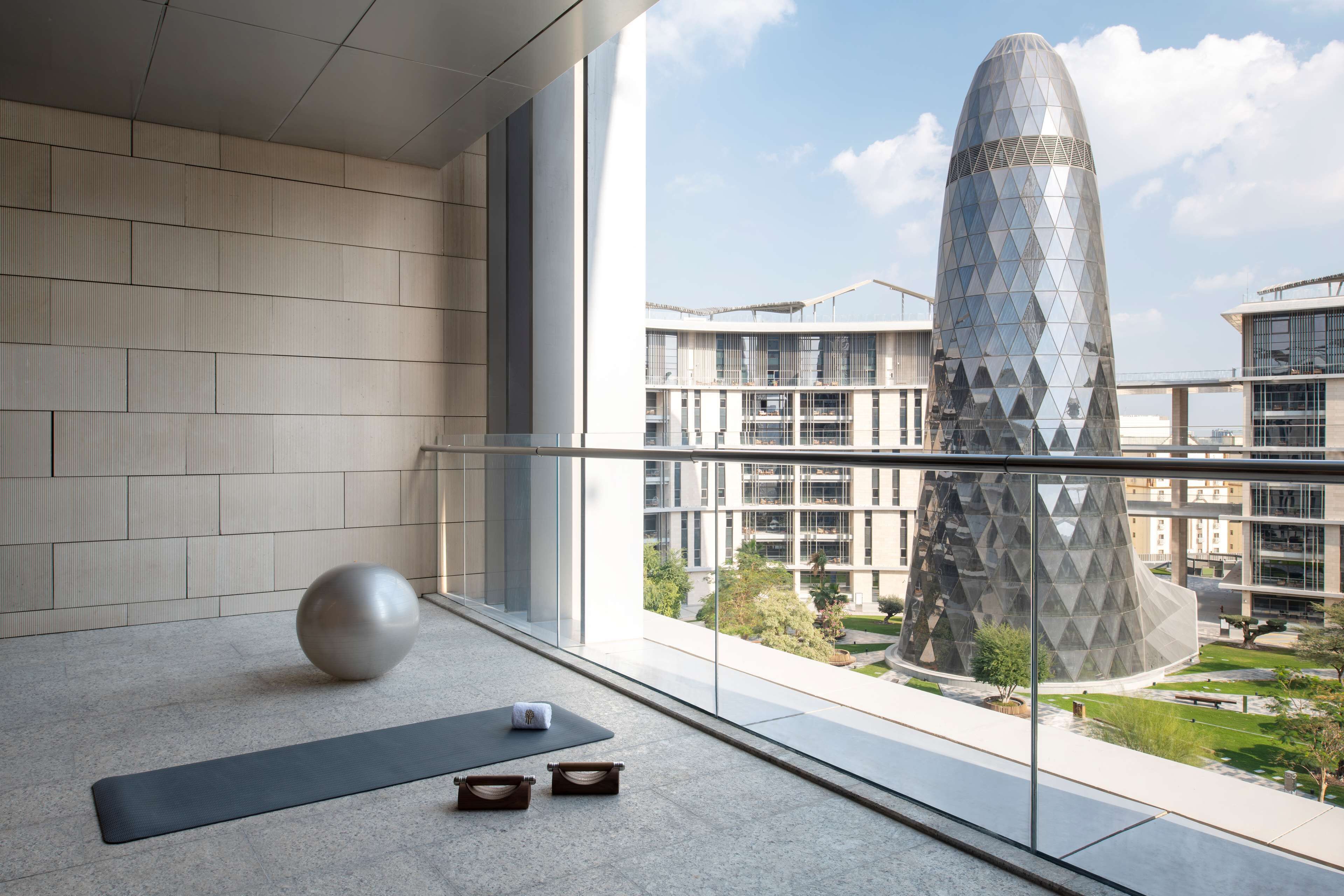 A modern interior with a large window, a yoga mat, and a meditation ball.