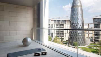 A modern interior with a large window, a yoga mat, and a meditation ball.