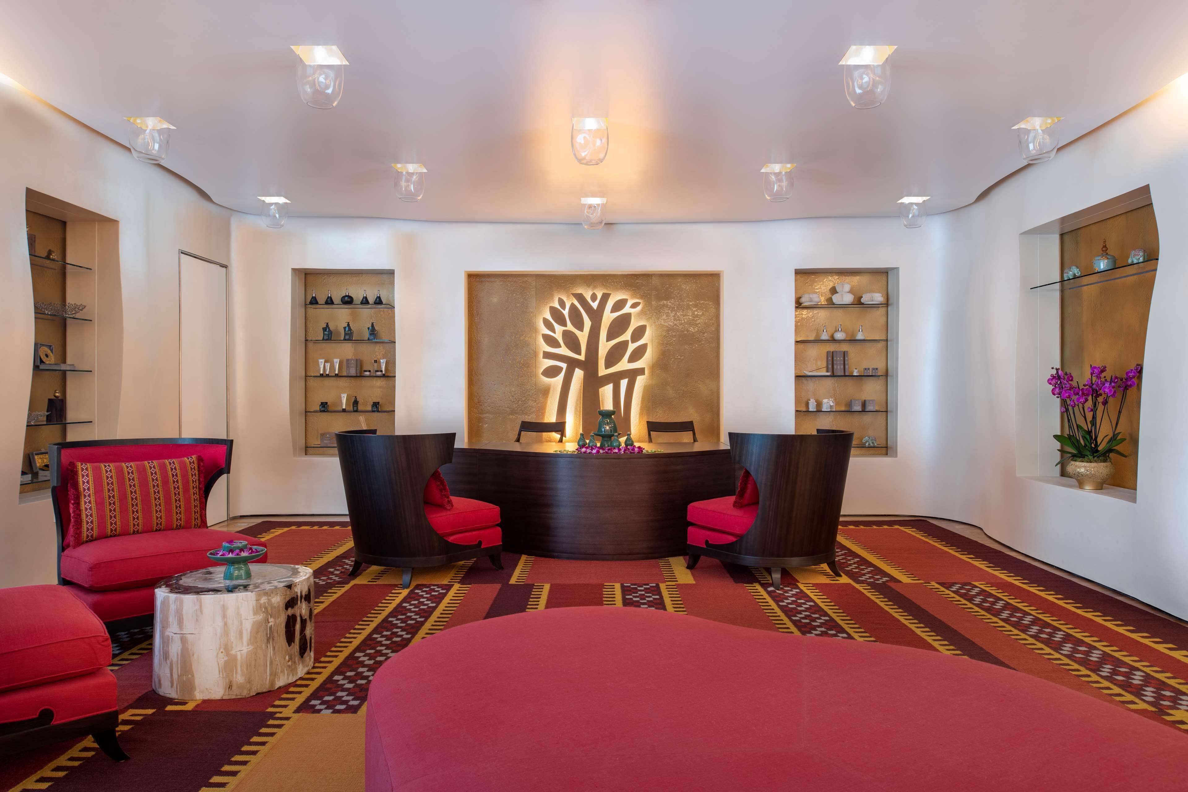 A lobby with a reception desk, seating area, and shelves with toiletries.