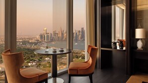 A high-rise room with a city view, a round table, two chairs, and a lamp. - Banyan Tree Doha at La Cigale Mushaireb (Doha)