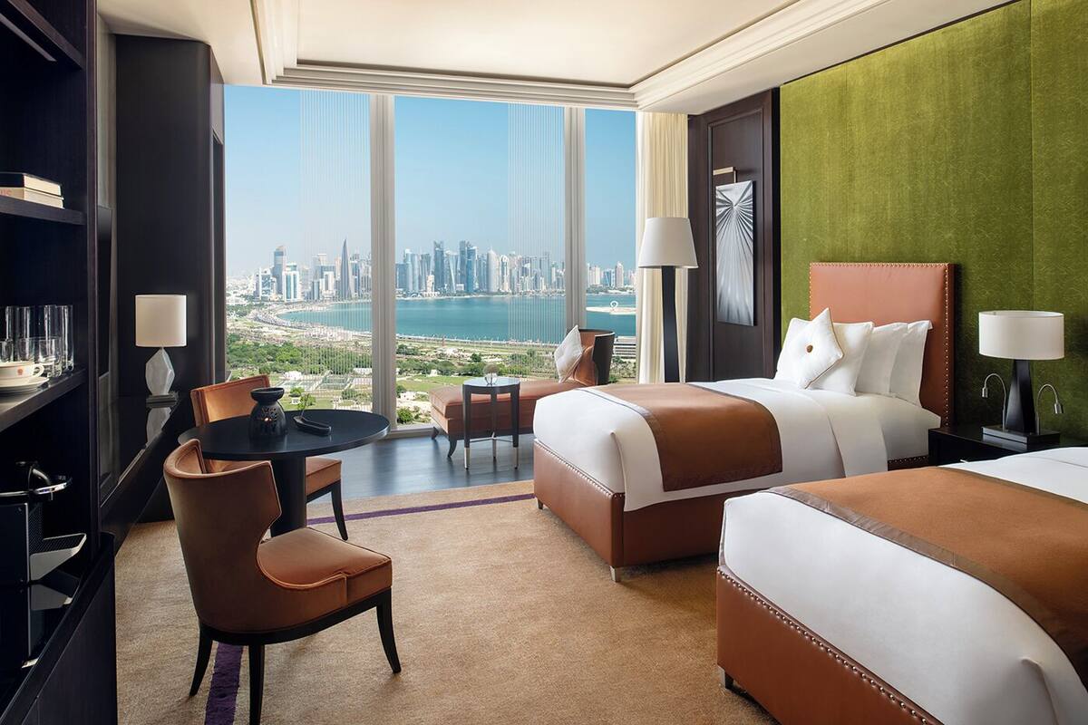 Habitación de hotel con vista a la ciudad, una cama, un escritorio y una silla.