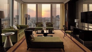 A high-rise room with a city view, a sofa, two armchairs, a coffee table, a TV, and a side table. - Banyan Tree Doha at La Cigale Mushaireb (Doha)