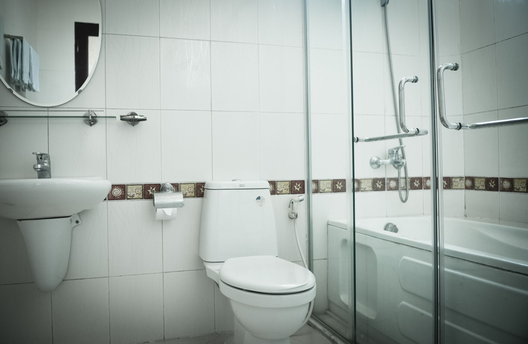 A bathroom with a toilet, sink, and glass-enclosed shower.