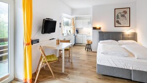 Et moderne hotelværelse med seng, skrivebord og tekøkken.