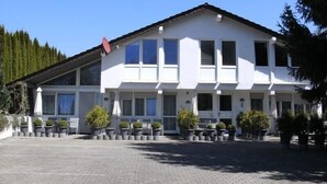 Un bâtiment à deux étages, doté d’un toit plat, de grandes fenêtres et d’une antenne parabolique.