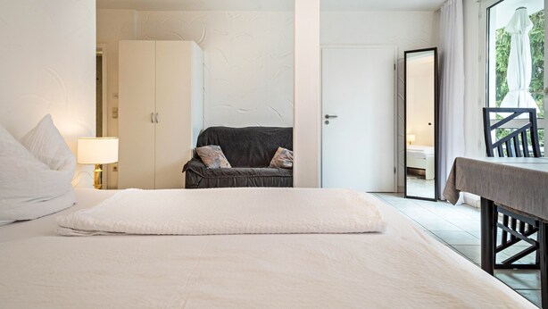 Une chambre avec un lit, un canapé, une table et un balcon offrant une vue.