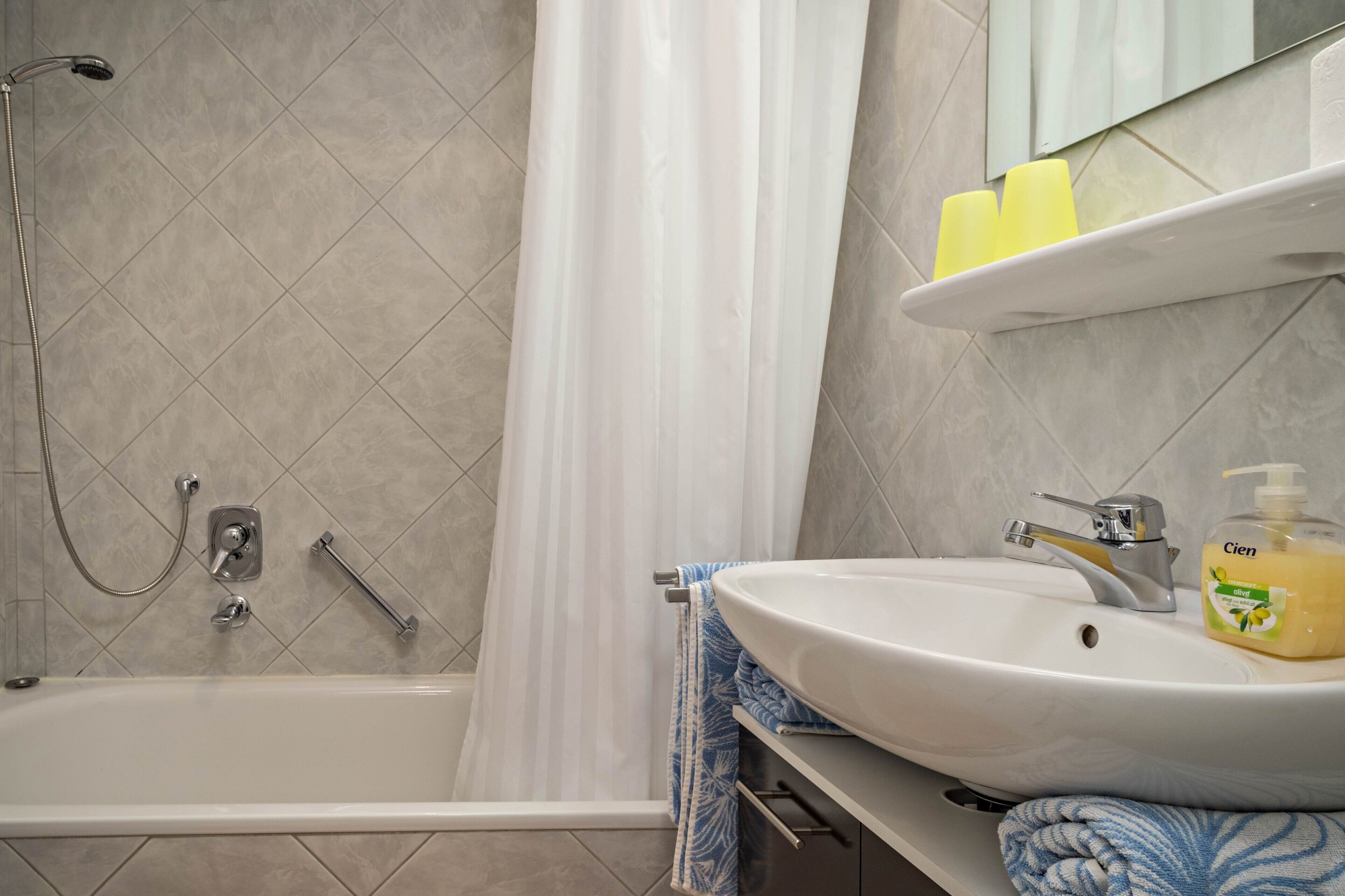 Ein Badezimmer mit Badewanne, Dusche, Waschbecken und Spiegel.