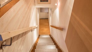 Eine Treppe mit hölzernen Geländern, einem strukturierten Boden und einem gerahmten Bild an der Wand.
