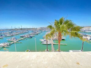 Ein Hafen voller Boote, Palmen und einem strahlend blauen Himmel.