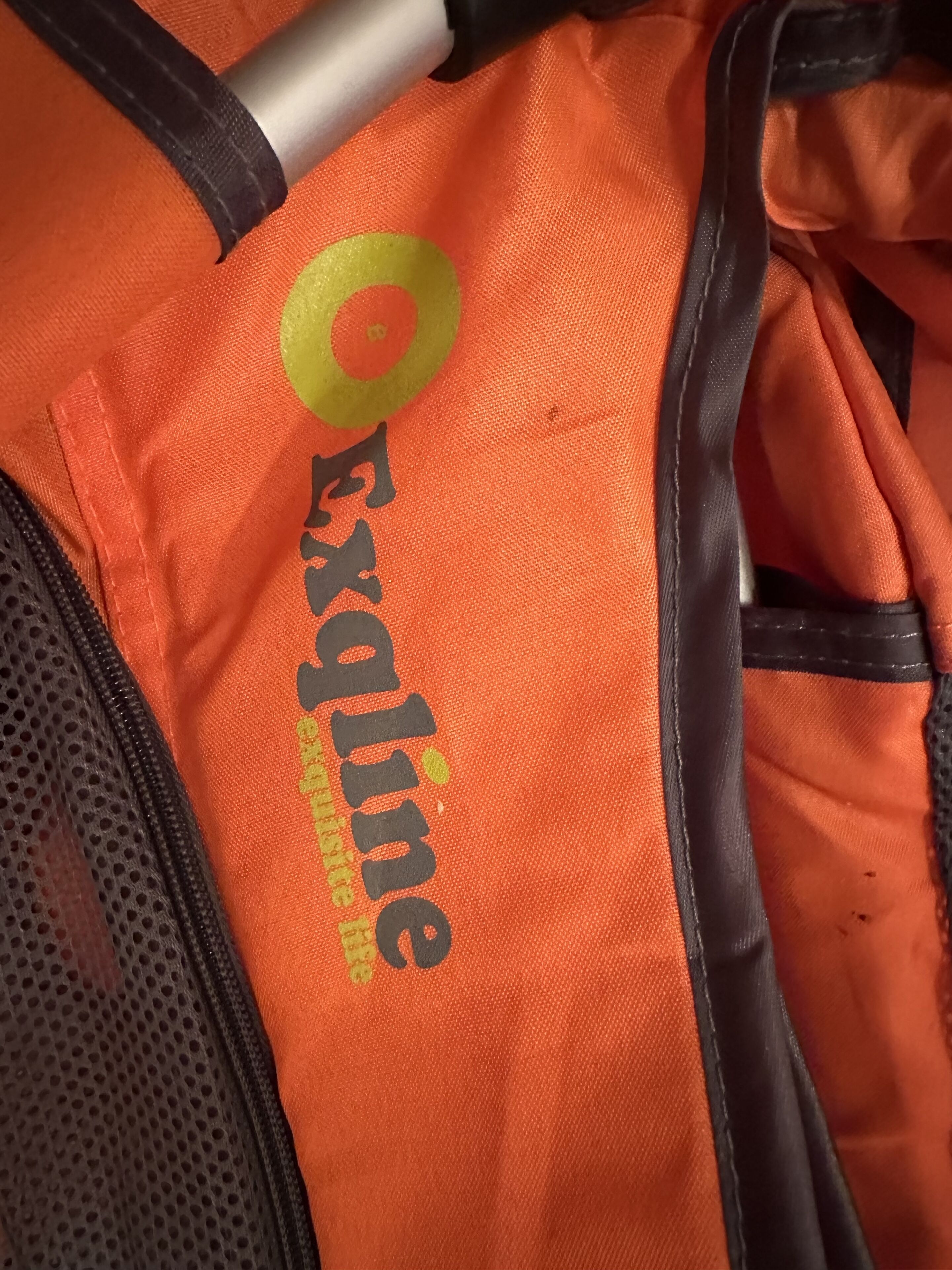 Primer plano de una bolsa naranja con el texto 'Exxaline' y un logotipo.