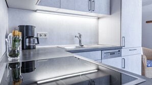 Een moderne keuken met roestvrijstalen apparatuur, een inbouwspoelbak en een koffiezetapparaat.