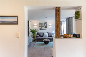 Un salon moderne avec un canapé gris, une table basse et une plante en pot.