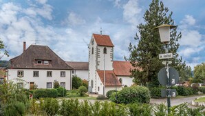 A white building with a clock tower, a sign reading 'Im Kellhof,' and a street lamp. - Schweizer Holiday Apartment – Relaxing Getaway at Lake Constance in Hemmenhofen (Gaienhofen)