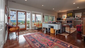 A spacious living area with a large window, a dining table, and a cozy seating area.