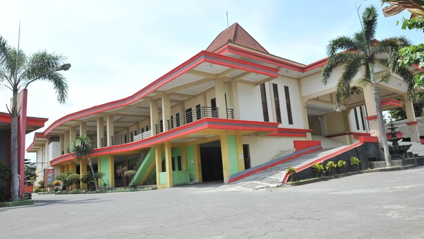 A large building with a red and white color scheme, multiple balconies, and a staircase leading to the entrance. - Hotel King's (Wates)