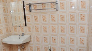 A bathroom with a white sink, a toilet, and a mirror. - Hotel King's (Wates)