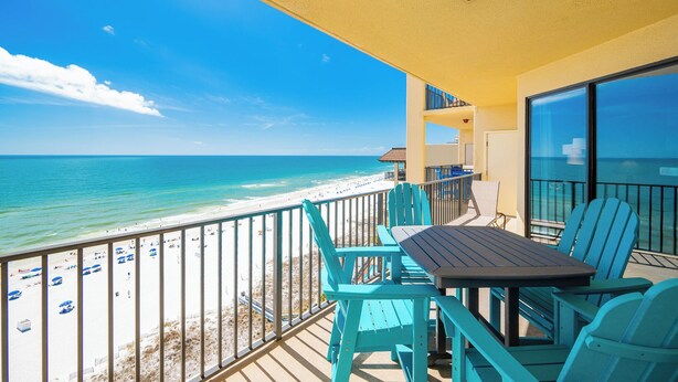 Un balcon avec vue sur la plage et l’océan.