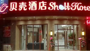 The exterior of a hotel with a prominent red neon sign.