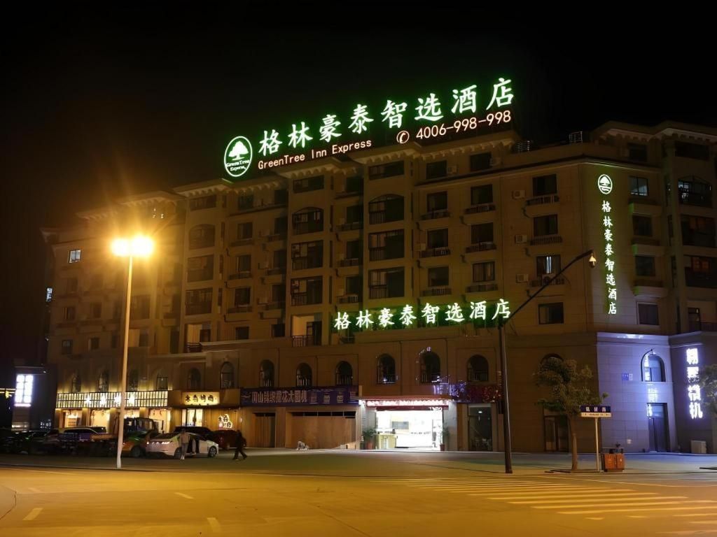 Um hotel com uma placa bem visível indicando ser um GreenTree Inn Express.