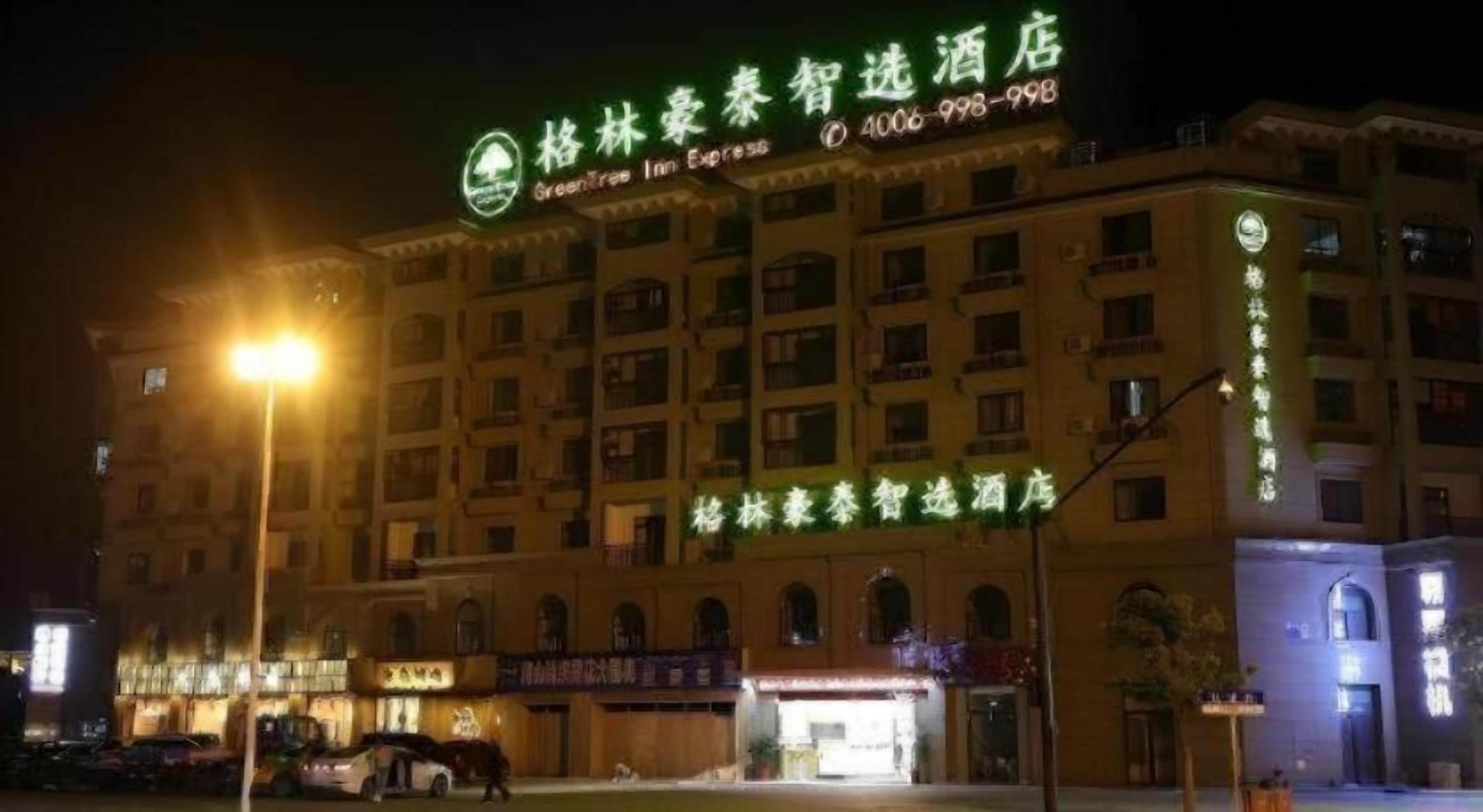 Un bâtiment d’hôtel doté d’une enseigne lumineuse, de plusieurs étages et d’une entrée bien visible.
