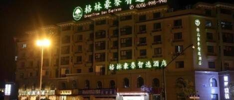 Un bâtiment d’hôtel doté d’une enseigne lumineuse, de plusieurs étages et d’une entrée bien visible.