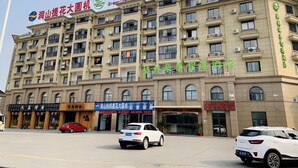 A multi-story hotel building with signage for 'Green Tree Inn Express' and 'Green Tree Inn'. - Greentree Inn Jiaxin Puyuan Kaixuan Road (Jiaxing)