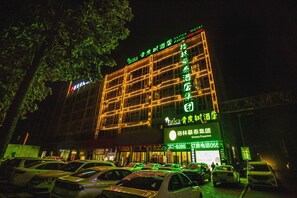 A hotel with a prominent sign for 'Vatica Hotel' and 'GreenTree Inn'.