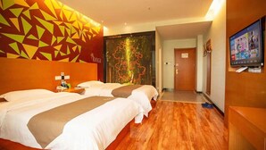 A hotel room with two beds, a TV, and a mural on the wall. - Vatica Jieshou City New Passenger Transport Center Hotel (Fuyang)