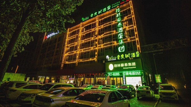 A hotel with a prominent sign for 'Vatica Hotel' and 'GreenTree Inn'. - Vatica Jieshou City New Passenger Transport Center Hotel (Fuyang)