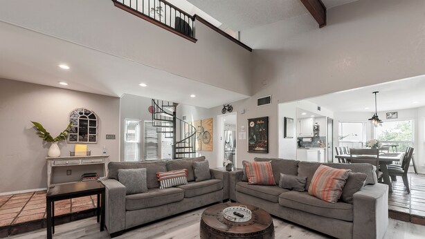 A spacious living room with a large gray sectional sofa, a wooden coffee table, and a staircase leading to an upper level. - 3Kingbeds/Fireplace/Deck/6 Flags/Airport (Grand Prairie)