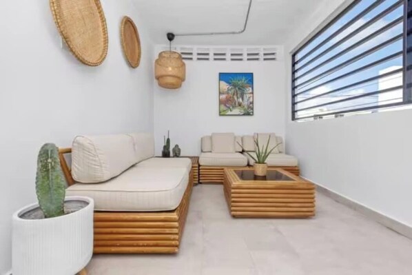 A modern living room with a sofa, a coffee table, and a cactus plant.