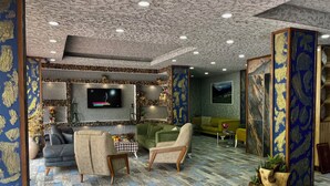 Una sala de estar moderna con una pared de piedra, un televisor de pantalla plana y un sofá verde.