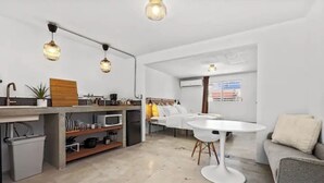 A modern kitchen with a dining table and a sofa. - Junior Suite Steps To Loiza Street & Best SJ Beach (San Juan)