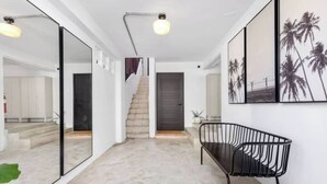 A modern interior with a staircase, a bench, and framed artwork on the wall. - Junior Suite Steps To Loiza Street & Best SJ Beach (San Juan)