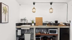 A compact kitchen with a built-in microwave, a coffee maker, and a sink. - Junior Suite Steps To Loiza Street & Best SJ Beach (San Juan)