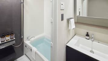 Un baño moderno con una bañera, una ducha, un lavabo y un espejo.