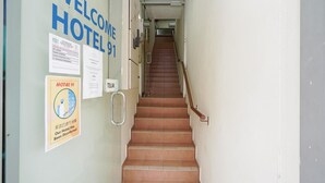 A hotel entrance with a staircase leading to the upper floor. There are signs on the wall indicating the hotel's name and a notice about recent disinfection. - Hotel O 9 @ Kajang Town (Kajang)