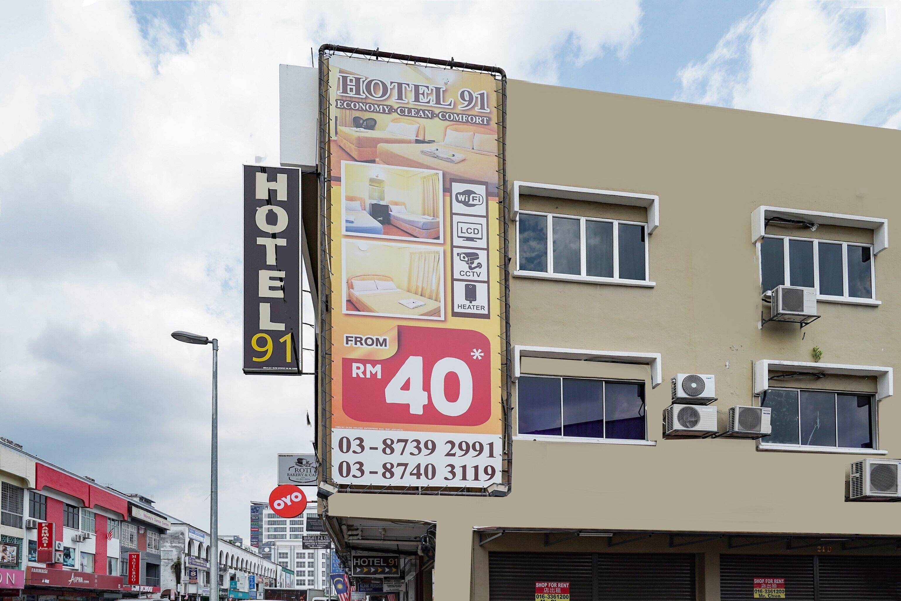 A hotel sign with amenities like WiFi, LCD TV, CCTV, and heater, and a price tag of RM 40.