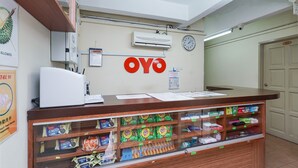 A reception area with a wooden counter, a clock, and a wall-mounted air conditioner. - Hotel O 9 @ Kajang Town (Kajang)