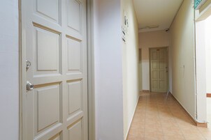 A hallway with white doors and tiled flooring.
