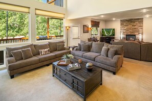 A spacious living room with a sectional sofa, a coffee table, and a fireplace.