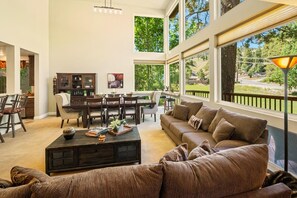 A spacious living room with a large window, a dining area, and a cozy seating area.