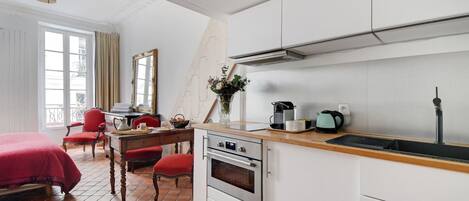 A compact kitchen with a stove, oven, and a coffee maker.