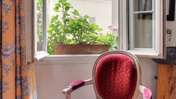 A room with a window, a chair, and a curtain.